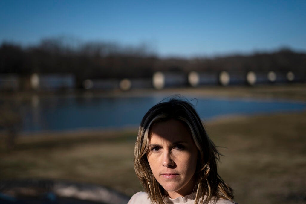 Jessica Conard looking at the camera with a pond in the background.